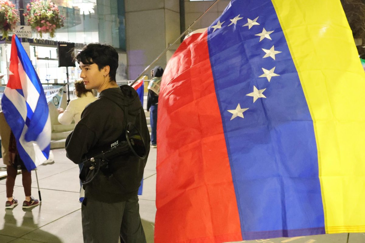 A protester holds Venezuela's flag amongst others in the crowd at Martin Luther King Jr. Library in San Jose on March 3.