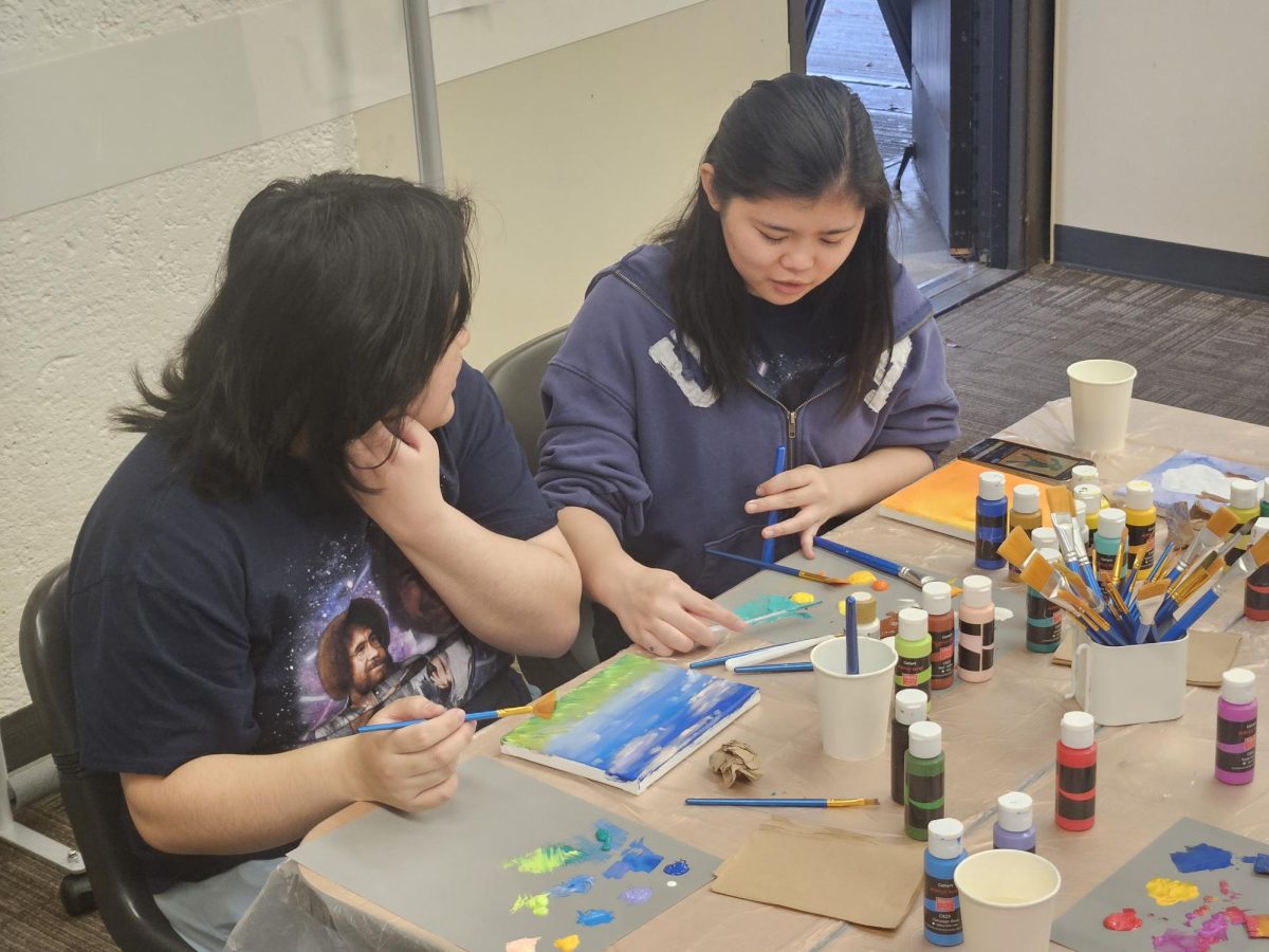 Allson Lyn, 20, animation major (left), makes small talk with Samantha Bagaporo, 19, psychology major (right), while they paint.