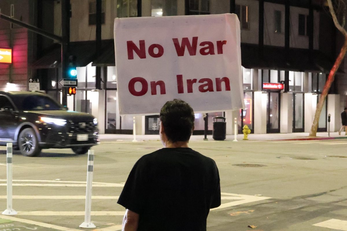 A protester faces the street while holding a picket sign, opposing the war on Iran in San Jose on March 3.