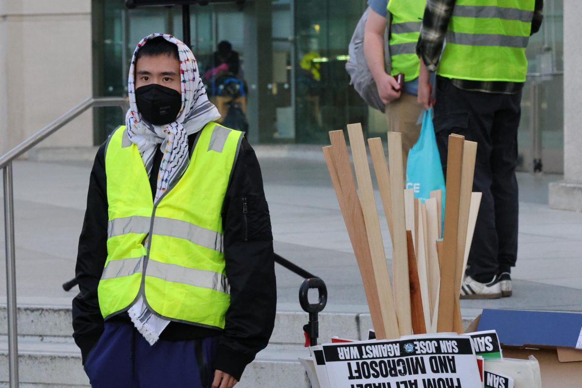 A protester stands next to a bundle of picket signs used by participants of the demonstration at Martin Luther King Jr. Library in San Jose on March 3.
