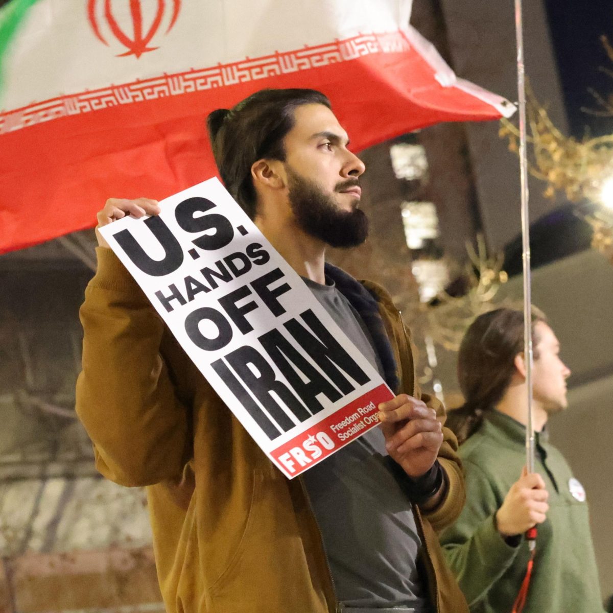 A protester conceals their face with a sign against the United States' involvement with Iran during the protest at Martin Luther King Jr. Library on March 3.
