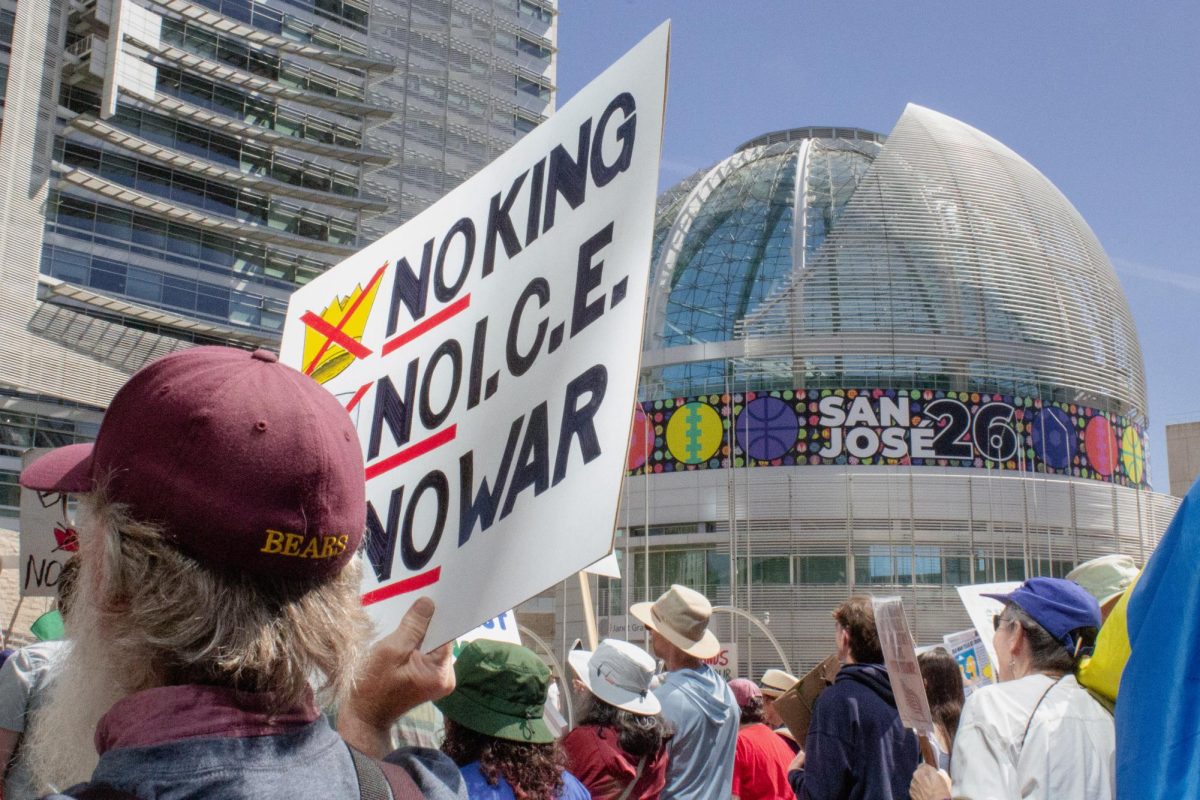 A man holds a sign during a protest outside of San Jose City Hall on March 28.