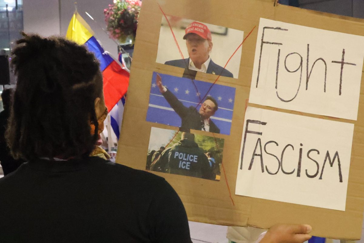 A protester holds a homemade sign that disavows the United States' decisions since President Trump's election at Martin Luther King Jr. Library in San Jose on March 3.