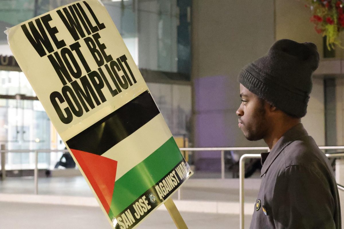 A protester holds a picket sign with the Palestinian flag outside of Martin Luther Kind Jr. Library, showing support for the demonstration's cause in San Jose, on March 3.