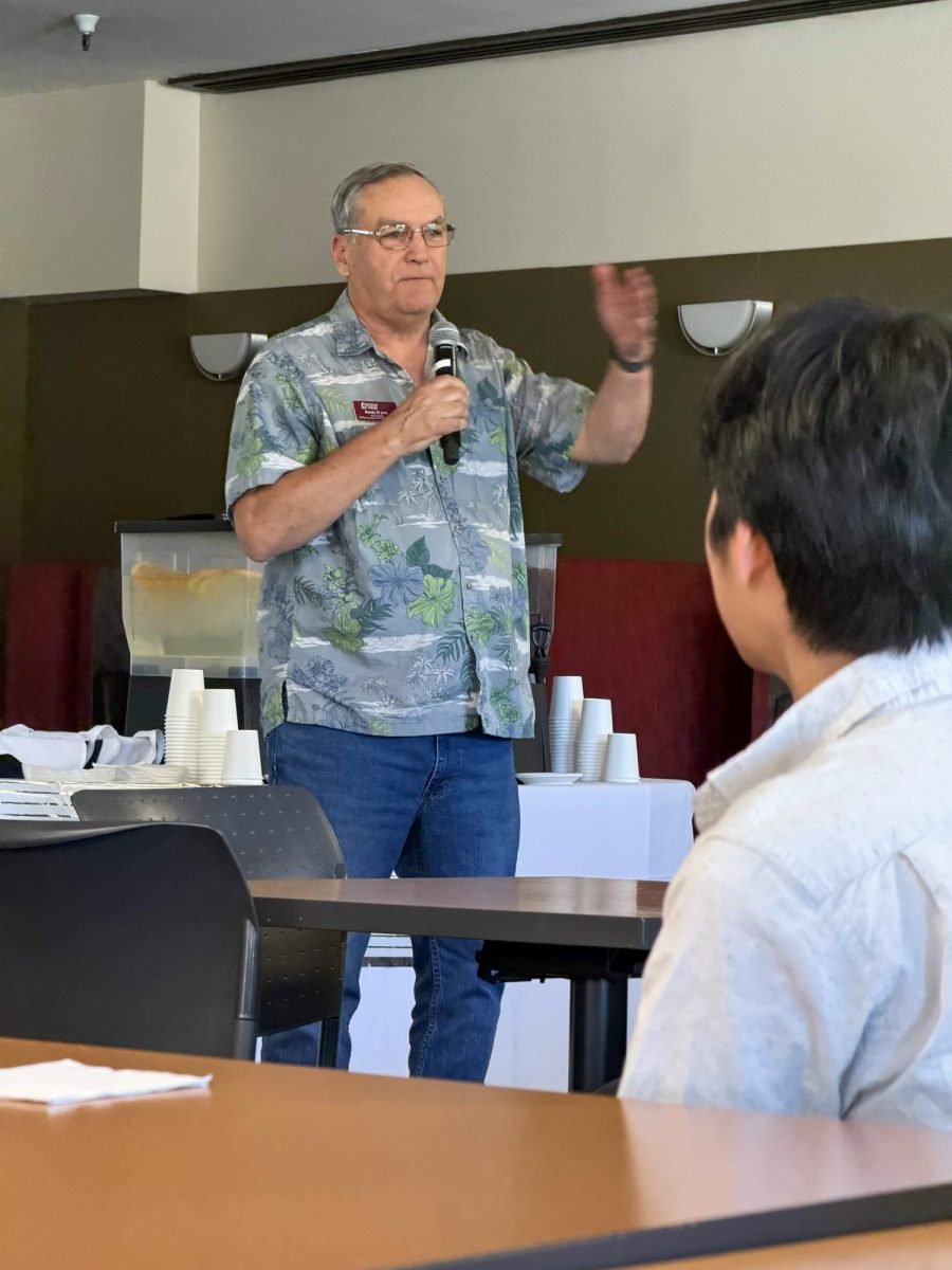 Randy Bryant, vice president of workforce innovation and economic advancement speaks to guests attending his retirement party in the fireside room on June 11.