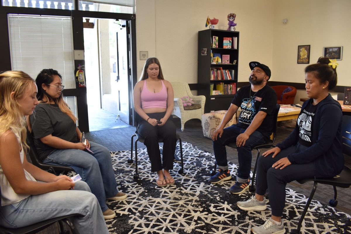 Attendees participate in chair yoga led by Noemi Teppang, International Student Program counselor on June 17 in the Women's Resource and Advocacy Center.